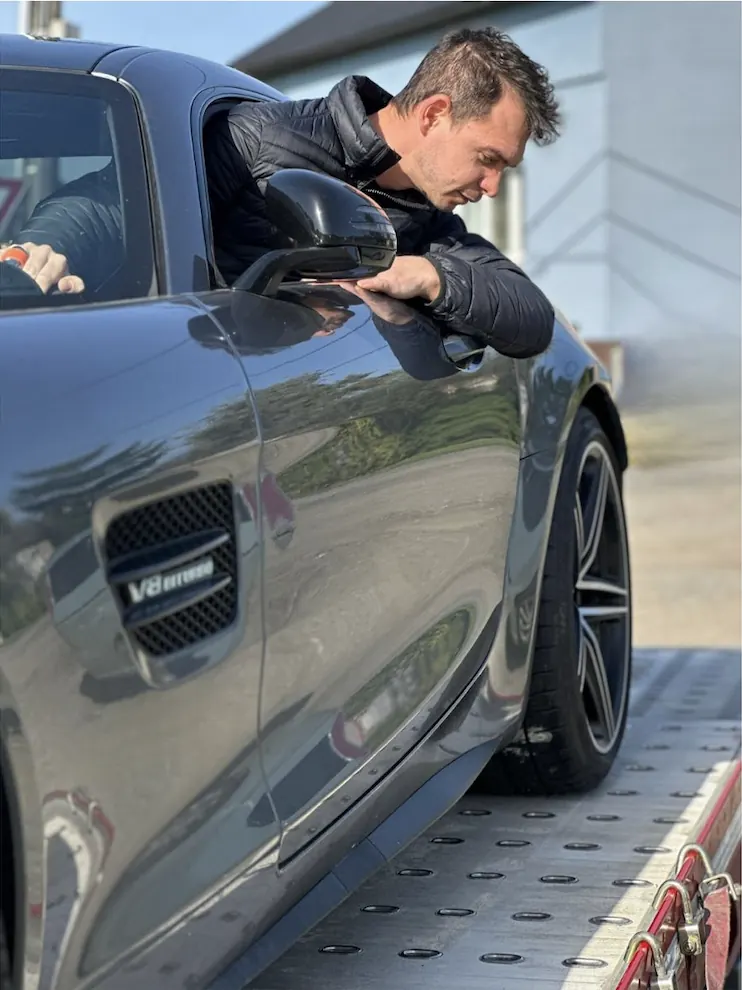 Ondřej Kopečný, jednatel Přeparkuj to, u vozu Mercedes-AMG GT na přívěsu